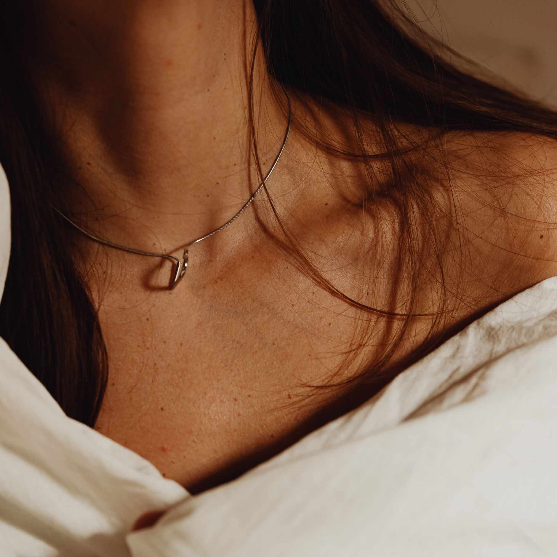 A fine chain on a woman's collarbone.