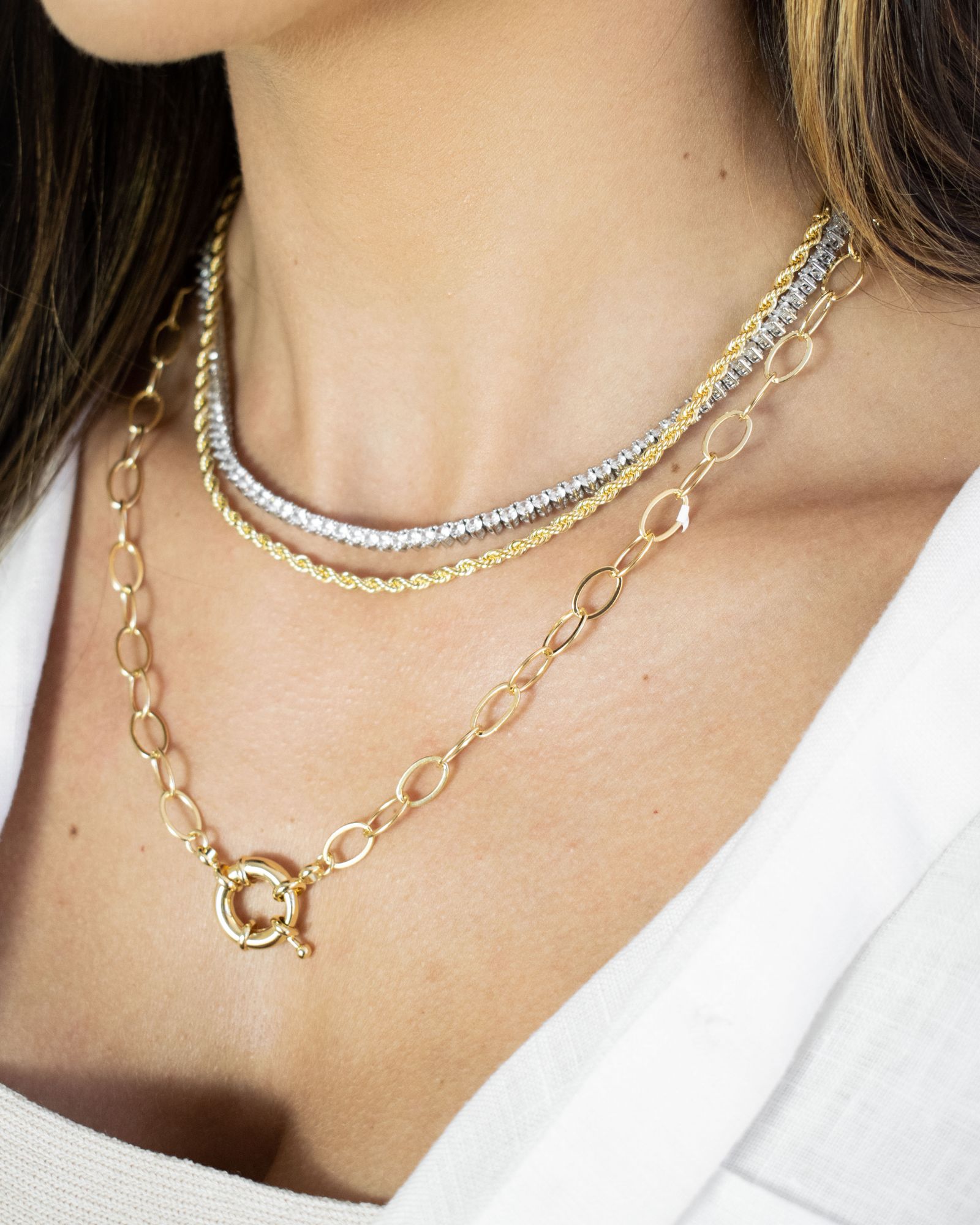 Fine gold and silver necklaces on a woman's neck.