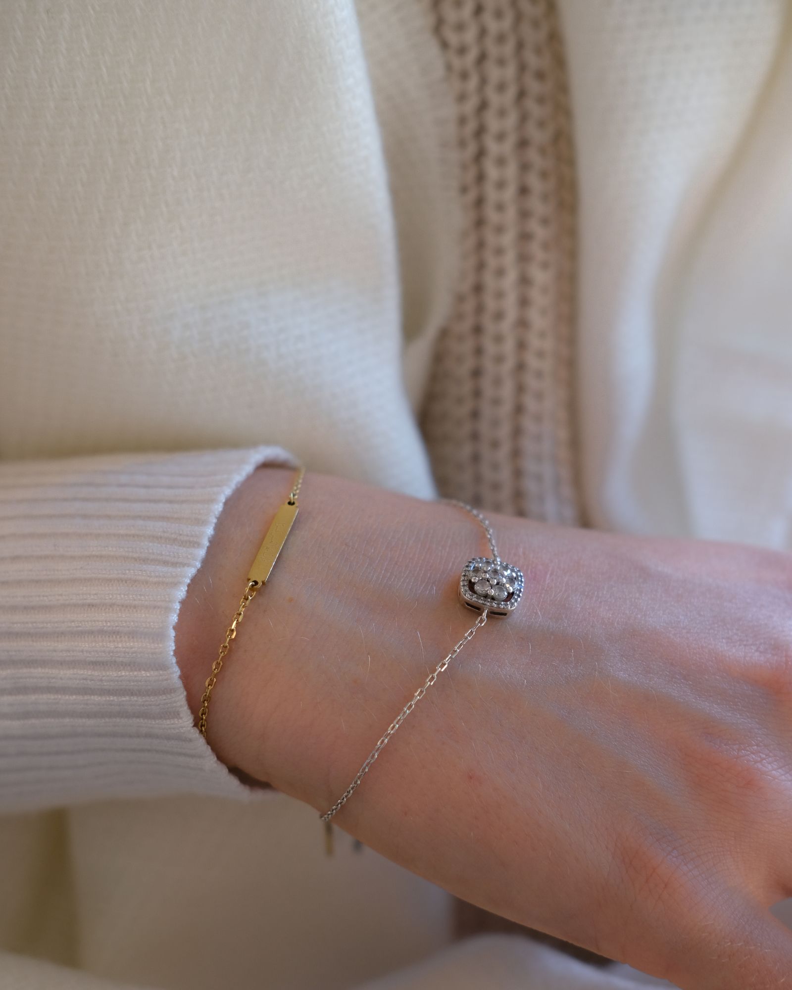 Gold and silver bracelets on a wrist.